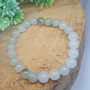 May include: A white and green gemstone bracelet with round beads.