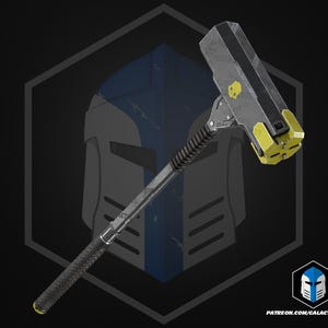 Pode incluir: Um martelo de guerra robusto com um cabo longo preto texturizado e uma cabeça cinza metálica. A cabeça do martelo inclui um emblema de caveira amarelo brilhante na lateral e uma face de impacto amarela multifacetada. O texto patreon.com/galacticarmory é visível.