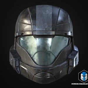 Könnte beinhalten: Ein verwitterter, dunkelgrauer Helm mit reflektierendem Visier. Der Helm weist sichtbare Kratzer und Abnutzungserscheinungen auf. Das Design ist kantig und futuristisch, was auf ein Science-Fiction- oder Militärthema hindeutet.