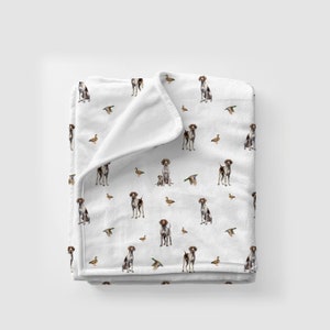 May include: White fleece throw blanket with a repeating pattern of brown and white hunting dogs and ducks.