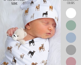 Könnte beinhalten: Ein weißer Swaddle mit einem Muster aus braunen, schwarzen und braunen Pitbull-Hunden. Ein Baby schläft im Swaddle und trägt eine weiße Mütze mit dem gleichen Pitbull-Hundemuster. Der Text "PERSONALIZATION OPTION WITH BABY NAME" befindet sich oben im Bild. Der Text "AVAILABLE IN 5 COLORS" befindet sich rechts im Bild mit fünf Farbmustern: Weiß, Salbeigrün, Hellblau, Grau und Altrosa.