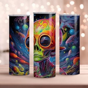 May include: Three stainless steel tumblers with colorful, psychedelic designs. The center tumbler features a close-up of an alien's face with glowing eyes and a skull-like head. The other two tumblers feature a space-themed design with planets, stars, and nebulae.