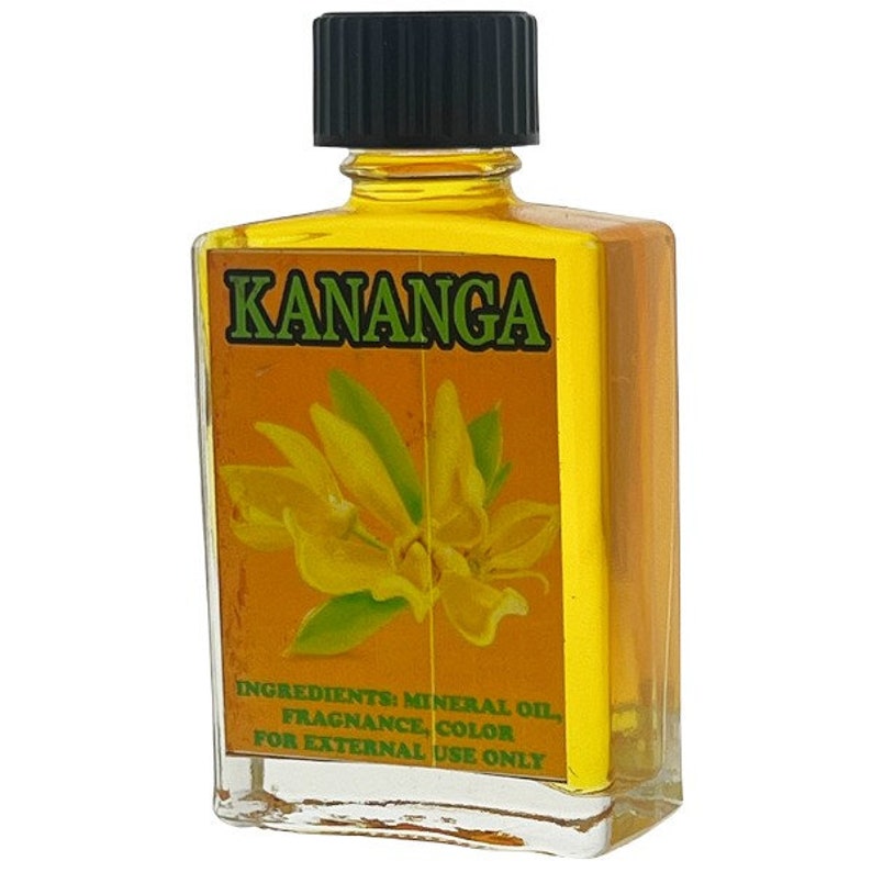 Puede incluir: Una peque&ntilde;a botella de vidrio de aceite de Kananga con una tapa negra. La botella est&aacute; llena de un l&iacute;quido amarillo y tiene una etiqueta amarilla con una ilustraci&oacute;n de flor verde. La etiqueta dice "Kananga" e "Ingredientes: Aceite mineral, Fragancia, Color. Para uso externo solamente."