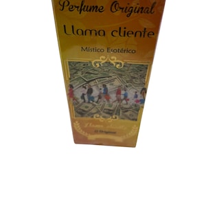 May include: A yellow box with gold lettering that reads "Perfume Original Llama Cliente Místico Esotérico". The box features an image of a group of people standing on a bed of US dollar bills.