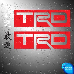 Op de afbeelding: Twee rechthoekige rode stickers met het zilveren TRD-logo. Links staan de Japanse karakters 最速 in wit en zwart. De achtergrond is een donkergrijs verloop bedekt met waterdruppels, met een blauw waterbestendig icoon.