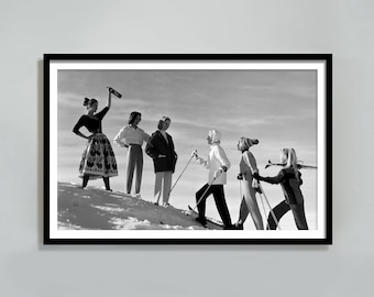 May include: A group of six people in winter clothing are skiing down a snowy slope. One person is holding a bottle of champagne in the air.