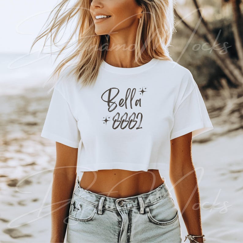 May include: White crop top with the text "Bella 2002" in black with a small star graphic.