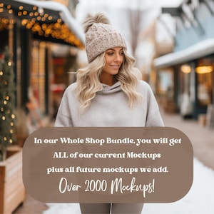 May include: A woman wearing a gray hoodie and a beige knit beanie with a pom pom walks through a snowy street lined with shops. The text "In our Whole Shop Bundle, you will get ALL of our current Mockups plus all future mockups we add. Over 2000 Mockups!" is displayed on a brown background.