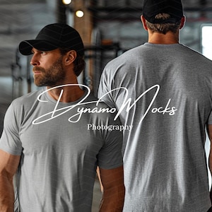 May include: Two people wearing gray t-shirts and black baseball caps. The t-shirts are plain and the caps are solid black.