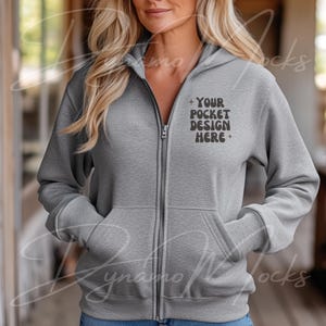 May include: A gray zippered hoodie with a front pocket. The pocket has the text "YOUR POCKET DESIGN HERE" printed on it.