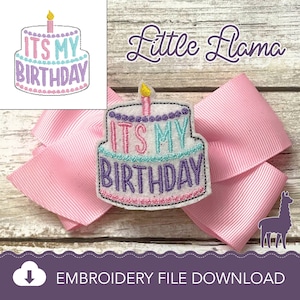 May include: Embroidered patch with a white cake with pink, blue, and purple frosting and the text "It's My Birthday". The patch is on a pink bow with a white wooden background. The text "Little Llama" is at the top of the image.