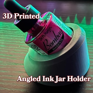 May include: A 3D printed angled ink jar holder with a magenta ink bottle labeled "Dr. Ph. Martin's Bombay Magenta Ink".