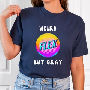 Puede incluir: Una camiseta azul marino con el texto "Weird Flex But Okay" en blanco. Un círculo colorido con la palabra "Flex" en su interior está por encima del texto.