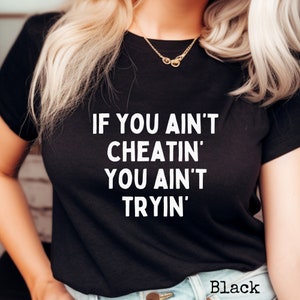 May include: Black t-shirt with white text that reads "If you ain't cheatin' you ain't tryin'".