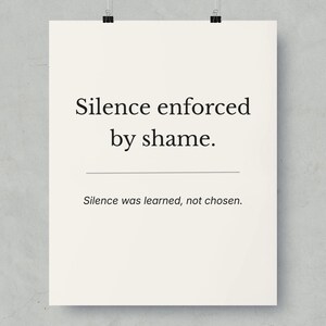 May include: A poster with the text "Silence enforced by shame." and "Silence was learned, not chosen." in black font on an off-white background. The poster is held by two black binder clips.