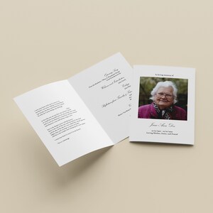 May include: A funeral program with a photo of an older woman wearing a pink jacket and a white scarf. The program includes a poem, a list of family members, and the text "In loving memory of Jane Ann Doe".