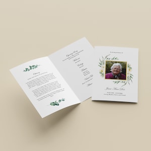 May include: A white funeral program with a floral design and a photo of a woman. The program includes an obituary, a list of the order of service, and the text "In loving memory of Jane Alice Doe".