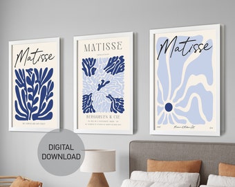 May include: Three framed art prints with the word "Matisse" in white text on a white background. The prints feature abstract blue and light blue floral designs.