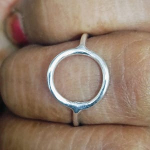 May include: A silver ring with a simple circle design.