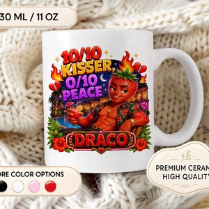 Könnte beinhalten: Weiße Keramik-Tasse mit einem farbenfrohen Design eines Erdbeer-Charakters mit dem Text "10/10 Kisser, 0/10 Peace" und "Draco". Die Tasse fasst 330 ml. Zusätzlicher Text lautet "Premium Ceramic High Quality".