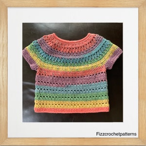 以下が含まれることがあります： 短い袖のレインボーのクロシェトップ。トップはピンク、オレンジ、イエロー、グリーン、ブルー、パープルなど、さまざまな色で作られています。トップは、波状のネックラインとクロシェの模様があります。