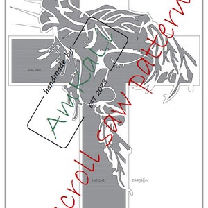 Könnte beinhalten: Ein graues und weißes Kreuz mit einem stilisierten Design eines Baumes mit Ästen. Das Kreuz trägt das Wort "INRI" oben und die Wörter "cut out" und "zaaglijn" unten. Die Wörter "handmade by Amkali EST 2023" sind in einem Kreis um das Kreuz geschrieben.