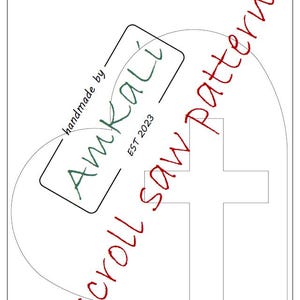 May include: A white paper scroll saw pattern with a cross design. The pattern includes the text "scroll saw pattern" in red cursive script. The AmKali logo is present, with the text "handmade by" above and "EST 2023" below.