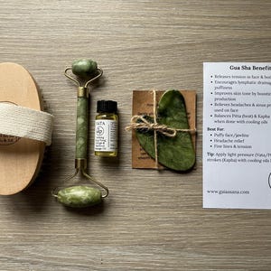 May include: A self-care kit featuring a wooden body brush, a green jade face roller, a small bottle of oil, and a green gua sha tool. A card lists the benefits of gua sha, including headache relief and fine lines.