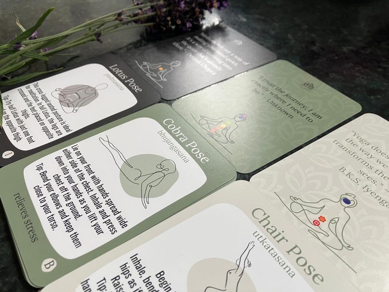 May include: A set of green and black yoga pose cards with illustrations and text. The cards feature poses like Lotus Pose, Cobra Pose, and Chair Pose. The text includes quotes about yoga and the journey of life.