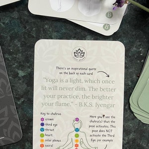 May include: A white card with a black lotus flower logo and the text "GAIA ASANA". The card features a quote by B.K.S. Iyengar: "Yoga is a light, which once lit will never dim. The better your practice, the brighter your flame."