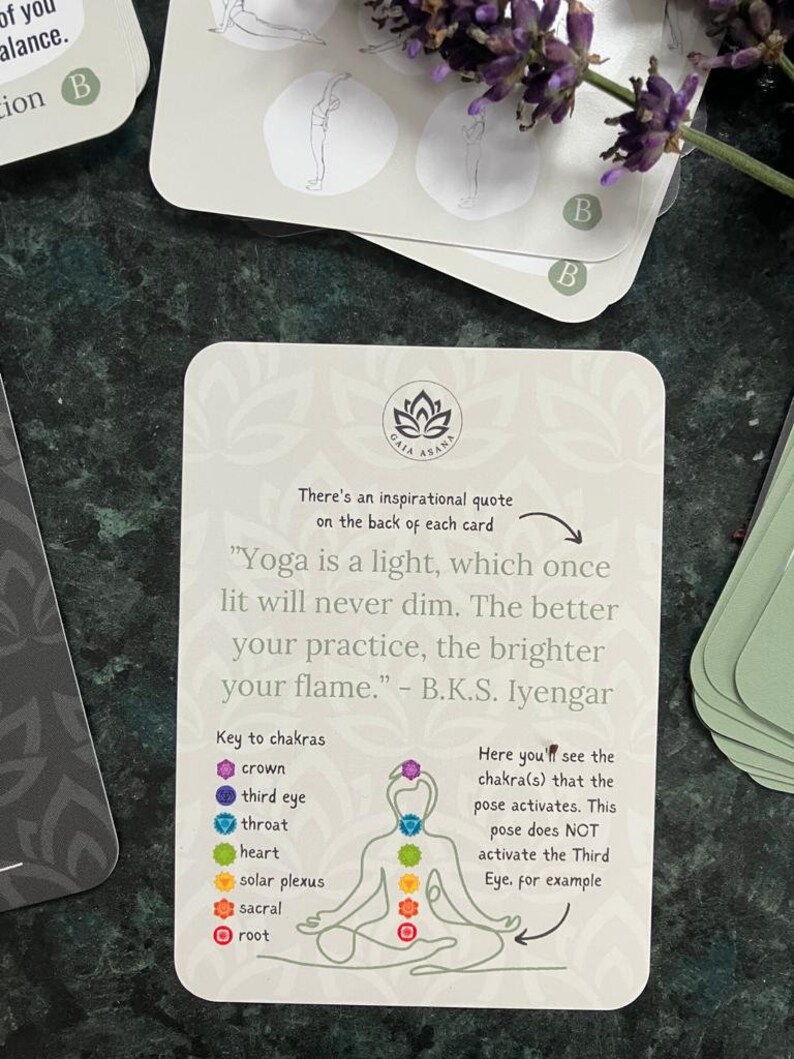 May include: A white card with a black lotus flower logo and the text "GAIA ASANA". The card features a quote by B.K.S. Iyengar: "Yoga is a light, which once lit will never dim. The better your practice, the brighter your flame."