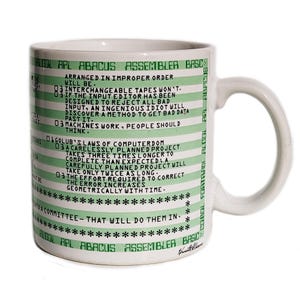 May include: White ceramic mug with green text and stripes. The mug features programming-related quotes and terms like "ALGOL APL ABACUS ASSEMBLER BASIC". The mug has a curved handle and is suitable for hot beverages.