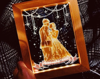 May include: A wooden frame with a clear acrylic insert featuring a silhouette of a couple dancing. The couple is surrounded by stars and a string of lights. The text "Forever and Always" is written on a banner below the couple.