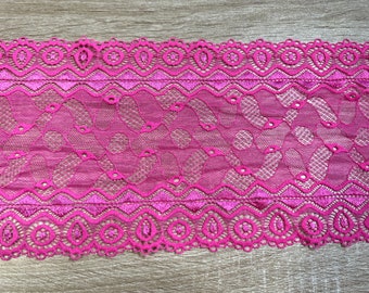 May include: Pink lace trim with a scalloped edge and a delicate floral pattern.