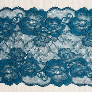 Puede incluir: Borde de encaje azul verdoso con un patrón floral. El encaje tiene un borde festoneado.