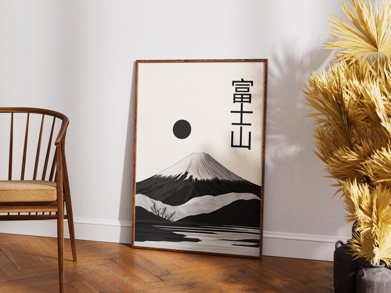 May include: Framed art print featuring a black and white illustration of Mount Fuji with a black sun and Japanese characters. The artwork has a minimalist style and is displayed in a wooden frame.