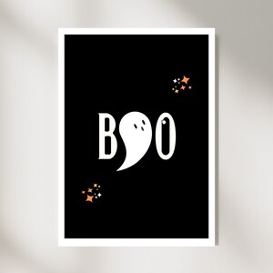 Puede incluir: Una tarjeta de Halloween imprimible en blanco y negro con la palabra "BOO" en texto blanco. Un fantasma blanco con dos ojos está en el medio de la "O". Hay pequeñas estrellas naranjas y amarillas dispersas alrededor de la tarjeta.