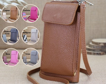 May include: A brown leather crossbody phone case with a zippered pocket and a long adjustable strap. The case is shown against a brown burlap background.