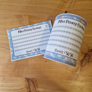 May include: A Mini Penny Savings chart and a cylindrical savings container, both in white and blue. The items feature a light blue border with a pattern of ice cream cones and other shapes. The text "Mini Penny Savings" and "Saves £50.50" are printed on both.