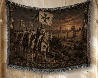 May include: A woven tapestry blanket featuring a scene of knights in armor riding horses toward a walled city at sunset. The knights carry flags with green crosses. The blanket has a decorative border with leaf motifs and fringed edges.
