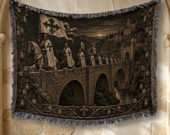 May include: A woven tapestry blanket featuring a procession of knights on horseback crossing a stone bridge toward a castle. The scene includes a white flag with a green cross, dark landscape tones, and a decorative border of pears and flowers.