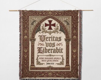 May include: A tapestry wall hanging with a cream-colored background and a decorative border in shades of brown and burgundy. The design includes a cross, ornate text, and the phrase "THE TRUTH SHALL SET YOU FREE" from John 8:32.