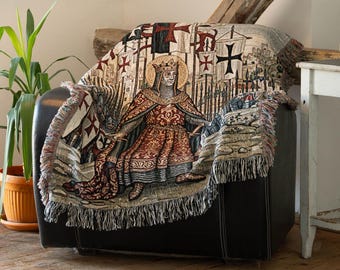 May include: A woven throw blanket featuring a central figure of a crowned monarch in ornate red and gold robes, surrounded by medieval banners with cross symbols. The textile has a fringed edge and a detailed tapestry-style design in muted tones.