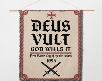 May include: A woven wall hanging with the text "DEUS VULT" in large black gothic lettering, with "GOD WILLS IT" below. The banner includes a red cross and crossed swords, with the text "First Battle Cry of the Crusades 1095".