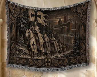 May include: A woven tapestry blanket featuring a dark, detailed scene of armored knights on horseback and on foot, carrying banners with black crosses. The background depicts a stone castle under a moonlit sky, surrounded by snowy pine trees.