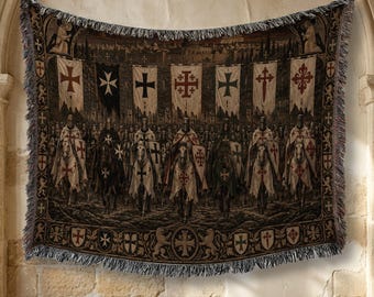 May include: A woven tapestry throw blanket featuring a detailed scene of armored knights on horseback carrying various heraldic banners and shields. The design includes multiple cross motifs, a dark color palette, and a decorative fringed border.