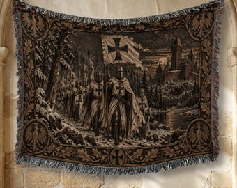 May include: A woven tapestry blanket featuring a group of knights in armor marching through a snowy forest toward a castle. The scene includes a flag with a cross, and the border is decorated with eagle emblems and oak leaves in brown and tan tones.