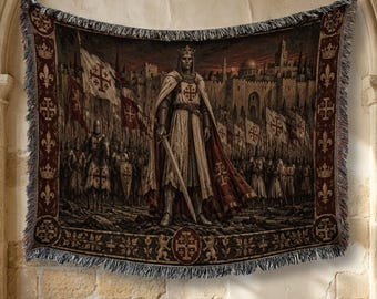 May include: A woven tapestry blanket featuring a central figure of a knight in armor and a cloak, holding a sword. The scene depicts a medieval army with flags bearing Jerusalem crosses before a stone city wall. The border has a dark red pattern.