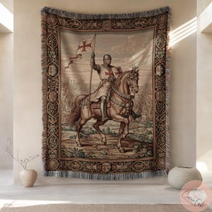 Könnte beinhalten: Gewebte Tapisserie mit einem mittelalterlichen Ritter auf einem Pferd, der eine Flagge mit einem roten Kreuz hält. Die Tapisserie hat einen detaillierten Rand mit aufwendigen Designs und Fransen am unteren Rand. Die Farbpalette umfasst Beige, Braun und Rottöne.