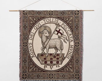 May include: Woven wall hanging featuring a lamb holding a flag with a cross, surrounded by text in a circular design. The lamb stands on a book with seven seals. The border is a repeating pattern in shades of brown and cream.